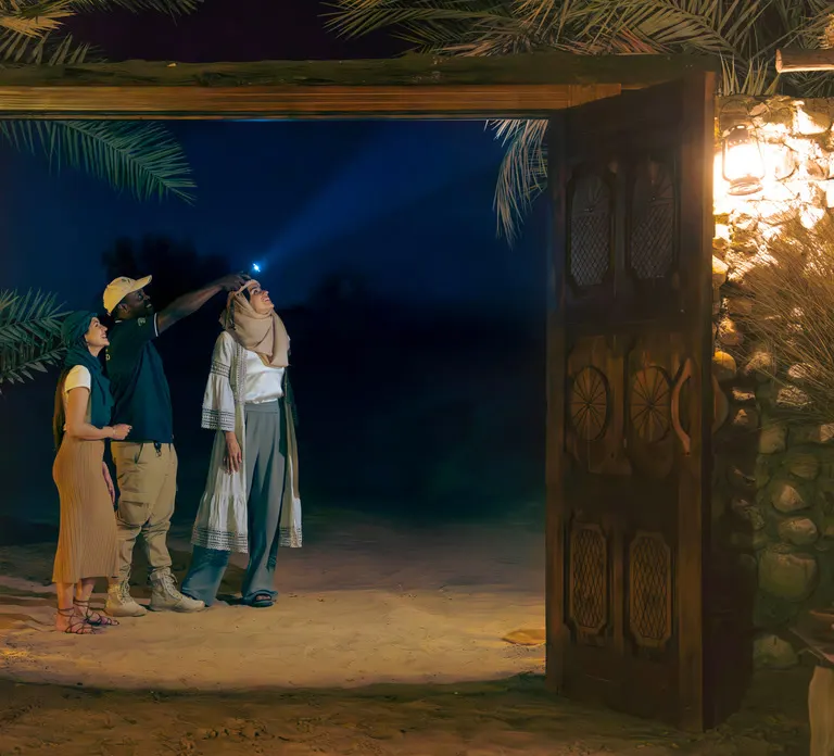 אורחים עם פנס בכניסה למחנה בלילה