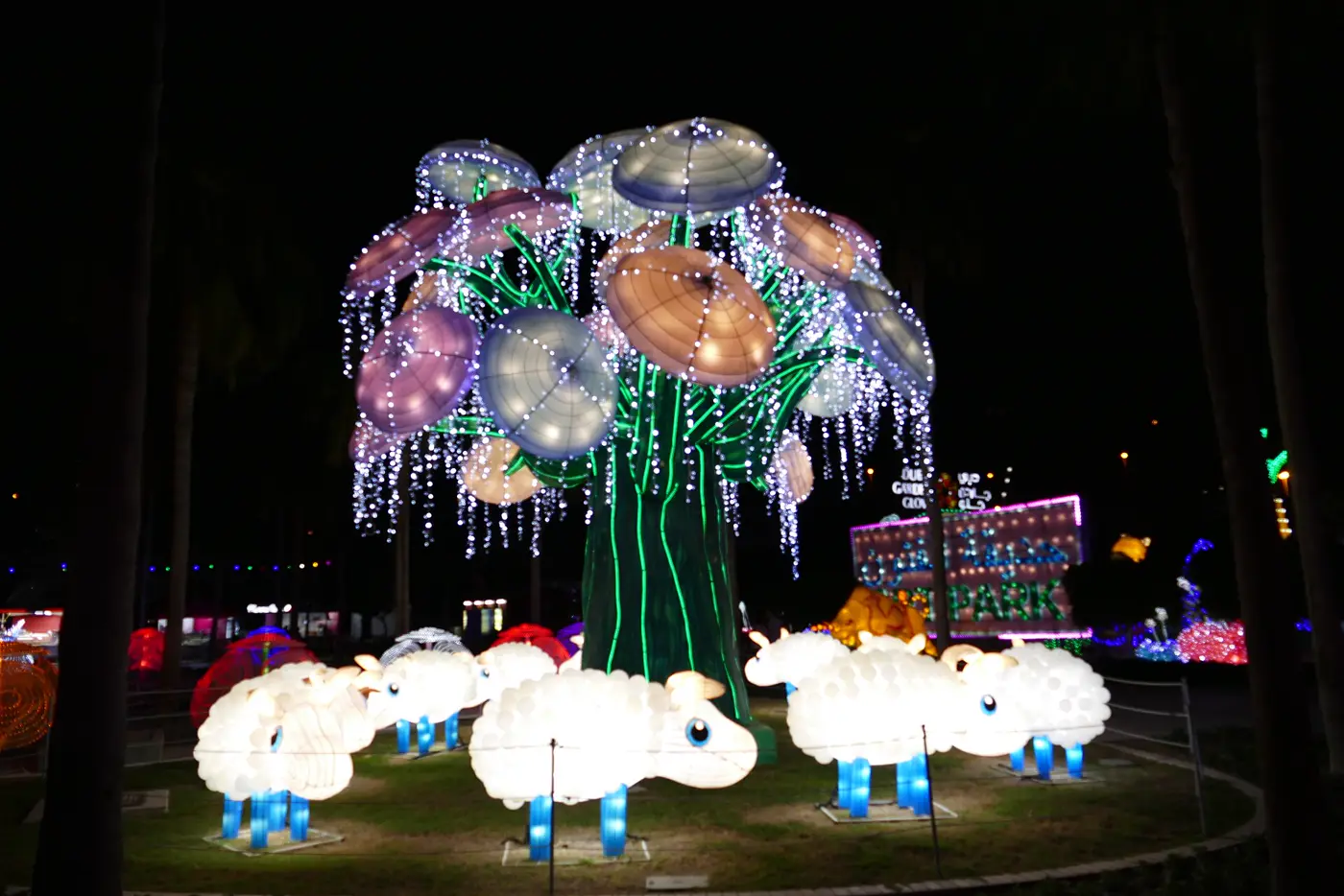 עץ מואר ועדר כבשים זוהרות בפארק Garden Glow בדובאי בלילה